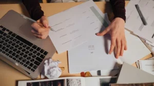 Person-reviewing-and-marking-documents-at-a-desk-1024x576